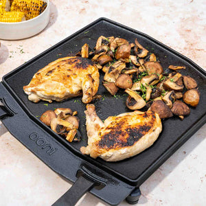 Grilled chicken and mushrooms on a cast iron skillet with 'Oni' branding.