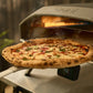 Pizza being cooked in a portable Doni pizza oven with a digital display showing temperature.
