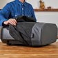 Person opening a black and gray UDO vacuum cleaner cover on a wooden table.